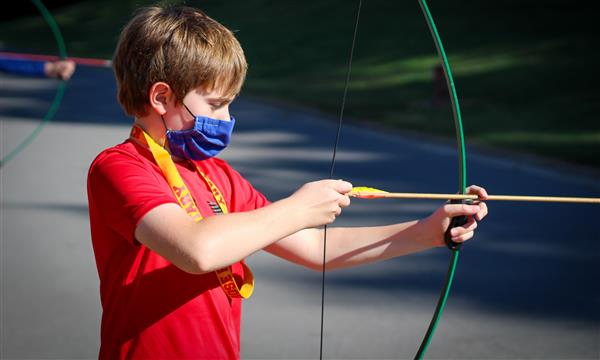 Boy gets ready to fire arrow
